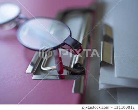 Binders, documents and glasses on a table 121100012