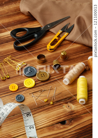 Crafting tools and materials arranged on a wooden table ready for sewing and creative projects 121100013