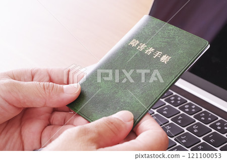 電腦前拿著殘障證的女士 121100053