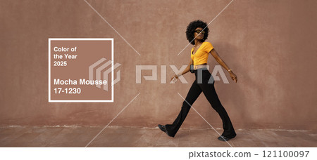 Fashion model showcases mocha mousse color trend in urban setting during sunny afternoon Fashion model showcases mocha mousse color trend in urban setting during sunny afternoon 121100097