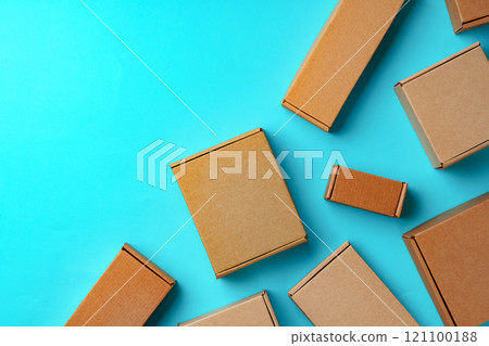 A collection of cardboard boxes arranged on a bright blue surface A collection of cardboard boxes arranged on a bright blue surface 121100188