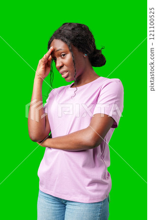 Young woman with curly hair shows a skeptical expression against a bright green background Young woman with curly hair shows a skeptical expression against a bright green background 121100525