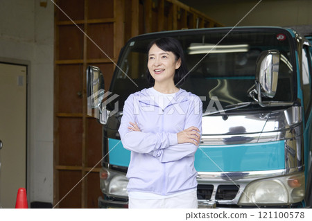 Portrait of a woman standing in front of a truck Portrait of a woman standing in front of a truck 121100578