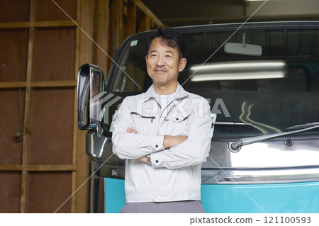 Portrait of a male worker standing in front of a truck Portrait of a male worker standing in front of a truck 121100593
