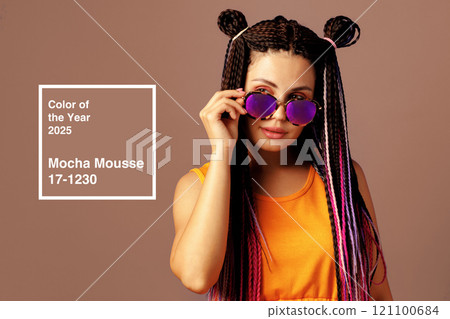 Young woman with braided hair and stylish sunglasses poses confidently in vibrant outfit showcasing future color of the year 121100684