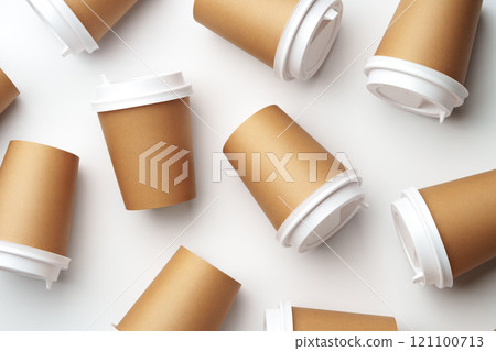 A collection of disposable coffee cups arranged artfully on a white surface 121100713