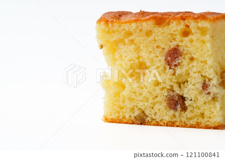 Moist cake slice with raisins displayed against a plain white background during a casual baking event 121100841