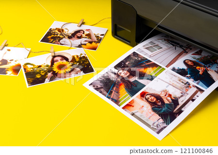 Printer printing colorful photos of people close up, yellow background Printer printing colorful photos of people close up, yellow background 121100846