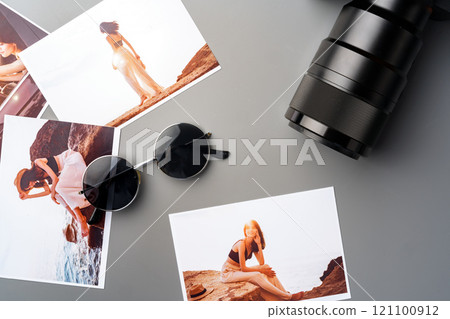 Photo camera with colorful printer photos on gray desk 121100912