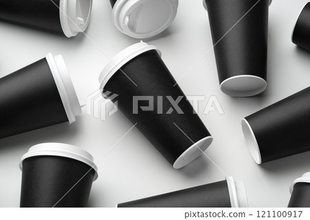 Multiple black takeaway coffee cups arranged in a repeating pattern on a white surface Multiple black takeaway coffee cups arranged in a repeating pattern on a white surface 121100917