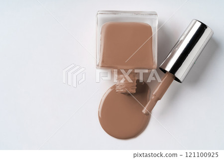 Nail polish bottle spilling soft beige polish onto a white surface in a minimalist setting during bright daylight Nail polish bottle spilling soft beige polish onto a white surface in a minimalist setting during bright daylight 121100925