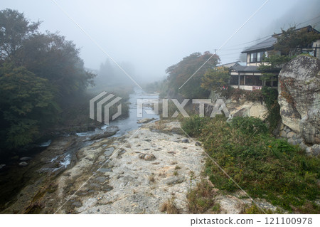 Yamadera, Yamagata, Japan. Misty riverbank with a house surrounded by lush greenery. Yamadera, Yamagata, Japan. Misty riverbank with a house surrounded by lush greenery. 121100978