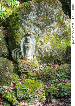 Risshaku-ji Temple at Yamadera, Yamagata, Japan. Stone statue partially covered in moss among rocks and greenery. 121101008