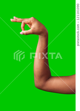 A hand making a gesture with a green background during daylight 121101090