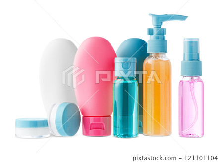Variety of colorful personal care bottles and grooming accessories arranged on a white surface 121101104