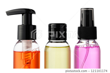 Various bottles with colored liquids and pumps arranged on white background 121101174