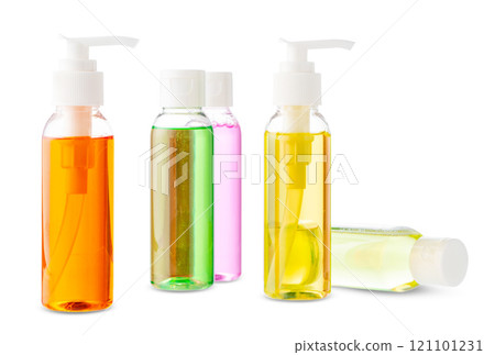 Variety of colorful personal care bottles and grooming accessories arranged on a white surface 121101231