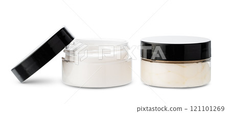 Open cosmetic jars showcasing different creams set against a clean white background 121101269