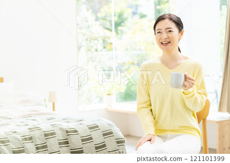 中年婦女在床上喝咖啡 121101399