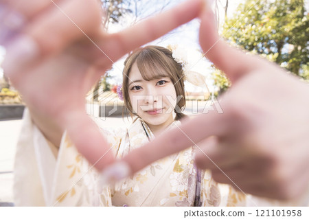 女性成年儀式 圖片:穿著和服的年輕女子製作手指框 女性成年儀式 圖片:穿著和服的年輕女子製作手指框 121101958