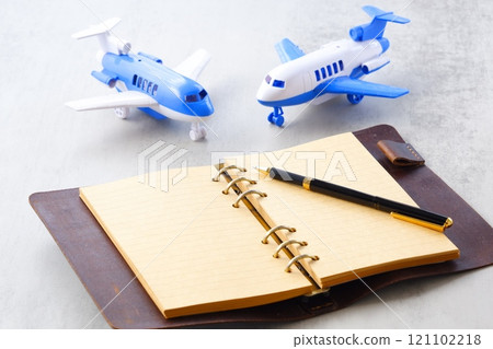 Image of an airplane and an open ring organizer planning your next long vacation trip Image of an airplane and an open ring organizer planning your next long vacation trip 121102218