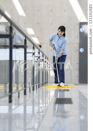 Image of building cleaning: Middle-aged female cleaning staff mopping the floor 121102883