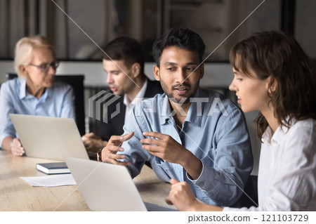 Multiethnic workmates analyzing project details or business plan on laptop 121103729