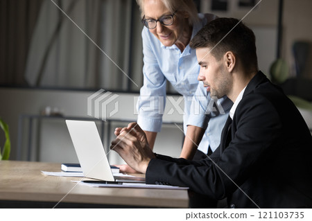 Two male female colleague reviewing new corporate software Two male female colleague reviewing new corporate software 121103735