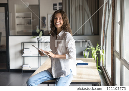 Happy woman working on tablet in modern workspace Happy woman working on tablet in modern workspace 121103773