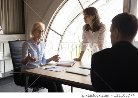 Group of employees gathered together at conference table for problem-solving Group of employees gathered together at conference table for problem-solving 121103774