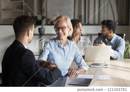 Older manager shake hands, greets applicant, finish job interview successfully Older manager shake hands, greets applicant, finish job interview successfully 121103781