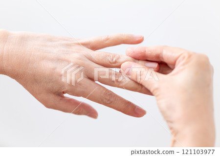 The hands of middle-aged to senior women applying moisturizing hand cream for skin care 121103977