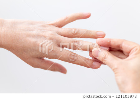 一位中老年婦女的手塗抹保濕護手霜來護理皮膚。 121103978