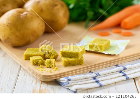 chicken bouillon cubes and fresh vegetables for soup on white wooden table, selective focus. 121104263