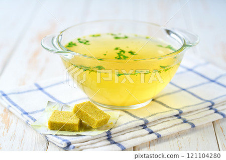 Broth cubes with ready to eat bouillon in a bowl on a kitchen table. Broth cubes with ready to eat bouillon in a bowl on a kitchen table. 121104280