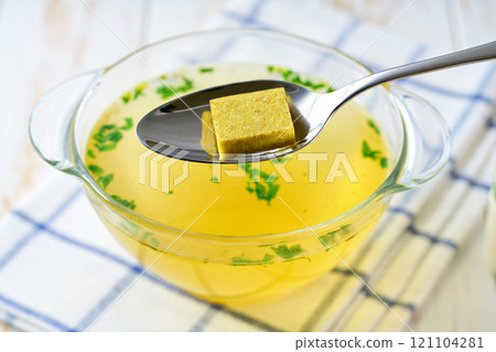 Broth cubes with ready to eat bouillon in a bowl on a kitchen table. Broth cubes with ready to eat bouillon in a bowl on a kitchen table. 121104281