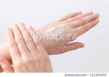 The hands of middle-aged to senior women applying moisturizing hand cream for skin care 121104347