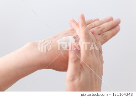 The hands of middle-aged to senior women applying moisturizing hand cream for skin care 121104348