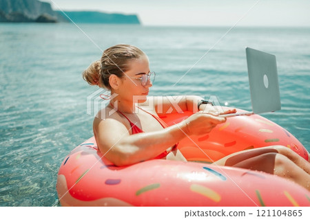 Woman laptop sea. Freelancer woman in sunglases floating on an inflatable big pink donut with a laptop in the sea. People summer vacation rest lifestyle concept Woman laptop sea. Freelancer woman in sunglases floating on an inflatable big pink donut with a laptop in the sea. People summer vacation rest lifestyle concept 121104865