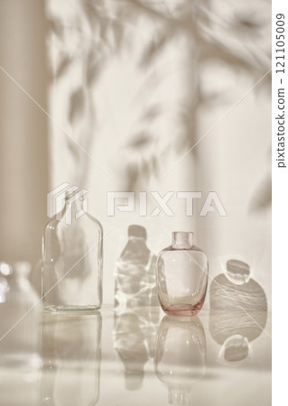 Warm sunlight streaming in through the window, beige background, flowers, vases, and a table with plants. Harmony of light and shadow. 121105009