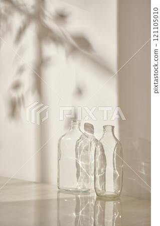 Warm sunlight streaming in through the window, beige background, flowers, vases, and a table with plants. Harmony of light and shadow. 121105010