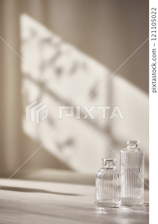 Warm sunlight streaming in through the window, beige background, flowers, vases, and a table with plants. Harmony of light and shadow. 121105022
