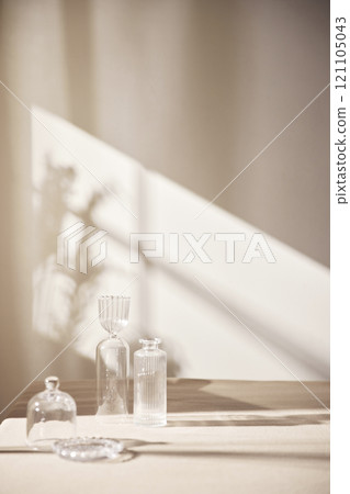 Warm sunlight streaming in through the window, beige background, flowers, vases, and a table with plants. Harmony of light and shadow. 121105043