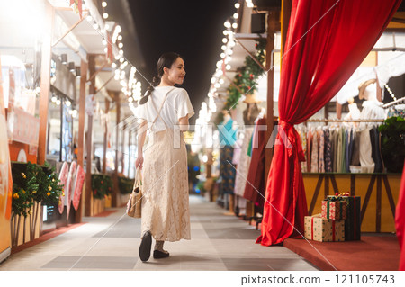 Asian woman walking at outdoors market on Christmas and happy new year holidays 121105743