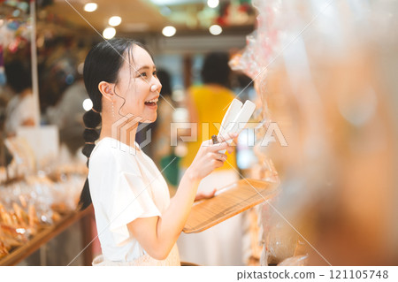 Happy smiling customer asian woman choosing whole grain bread at bakery shop Happy smiling customer asian woman choosing whole grain bread at bakery shop 121105748