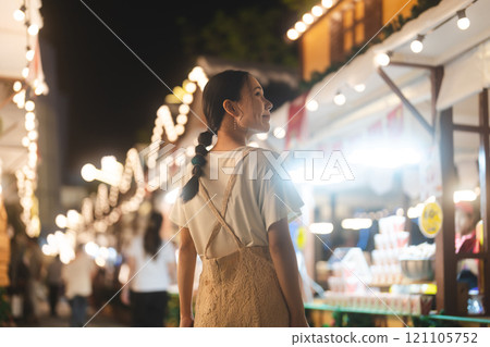 Asian woman walking at outdoors market on Christmas and happy new year holidays 121105752