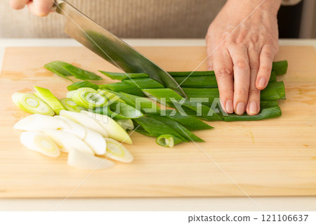 A woman's hands cutting green onions 121106637