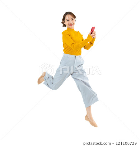 一名女子手持智慧型手機跳躍，透明背景為手工精確剪裁的 PNG 全身照片。 121106729