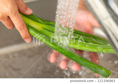 A man's hands washing green onions A man's hands washing green onions 121106863