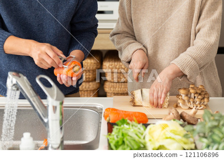 A middle-aged to senior couple preparing hotpot in the kitchen 121106896